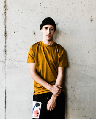 Modelo masculino vestindo camiseta na cor amarelo mostarda.